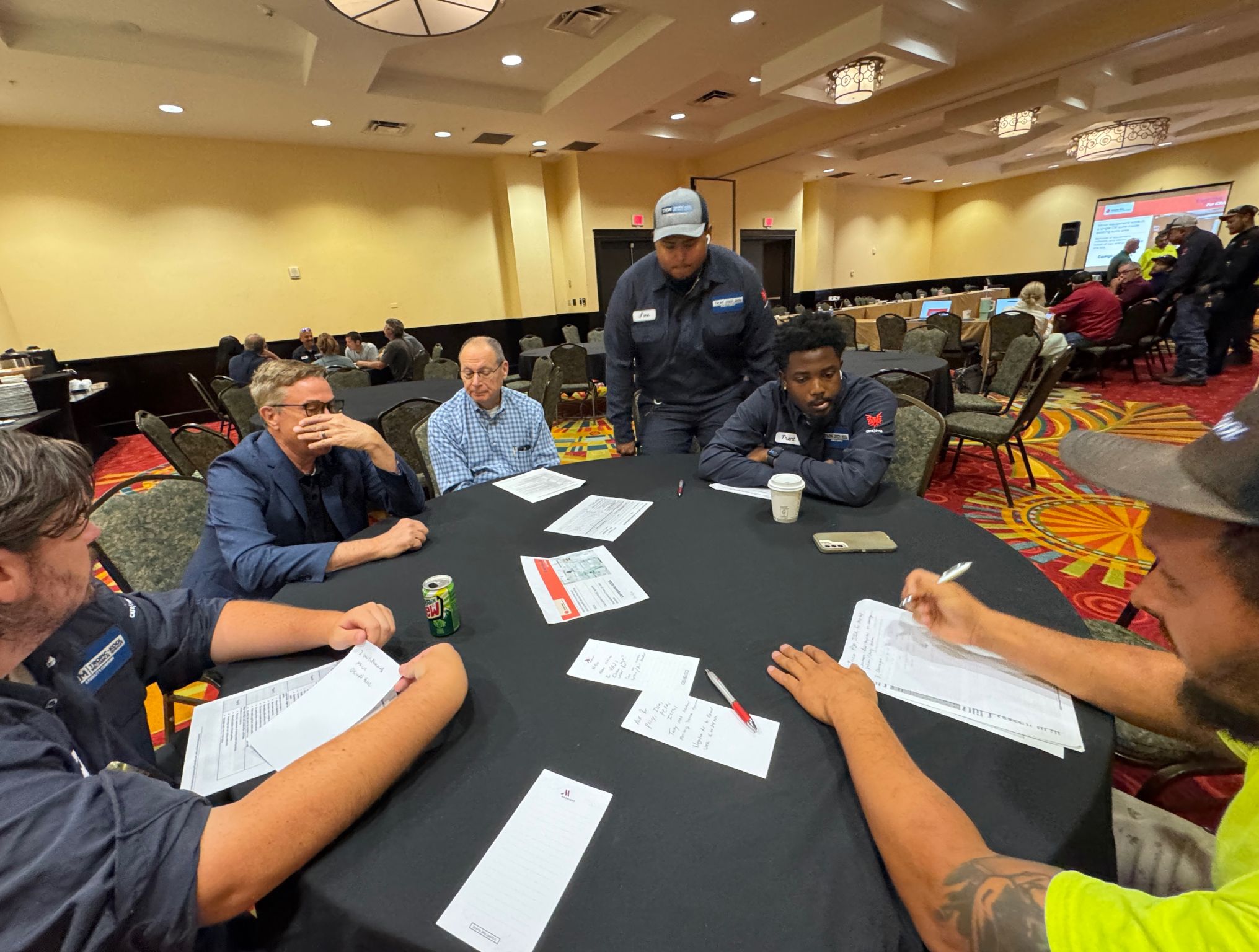 Trade workers at a table filling out ICRA permit paperwork during a class exercise